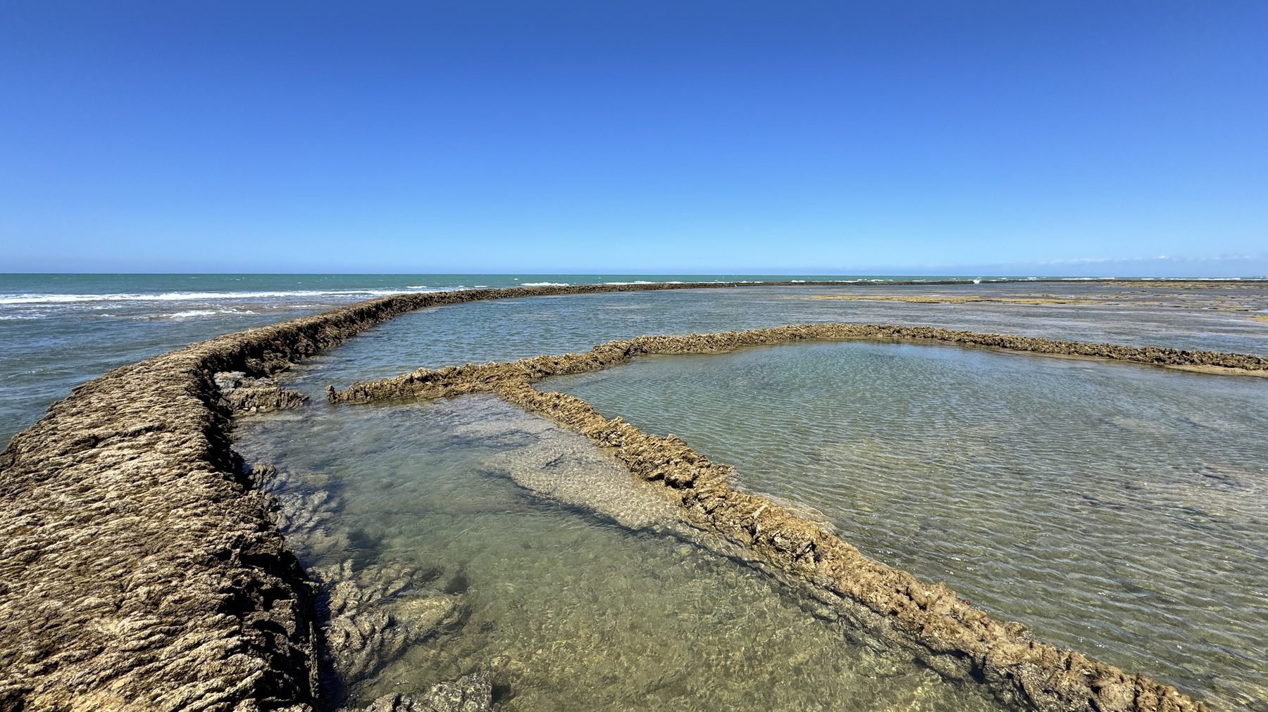 Muro de piedra seca de un corral con el agua retenida por la marea